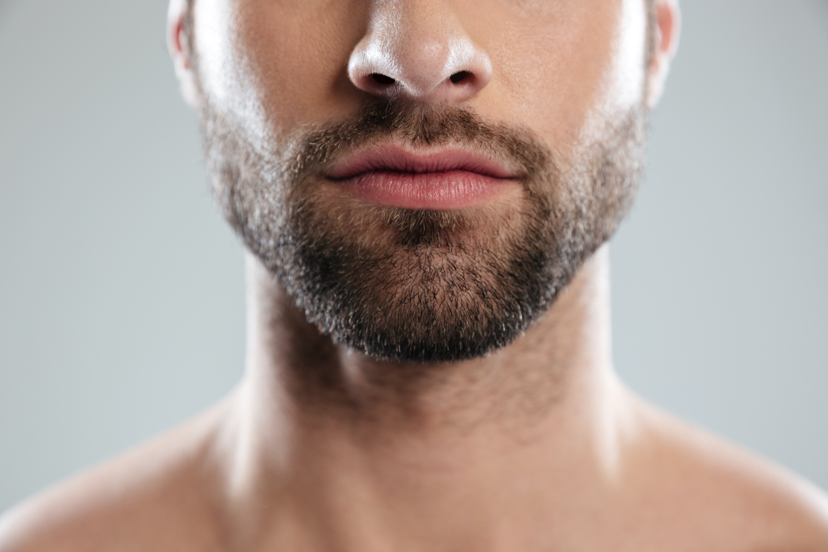 Cropped image of a half mans face with beard isolated over white background